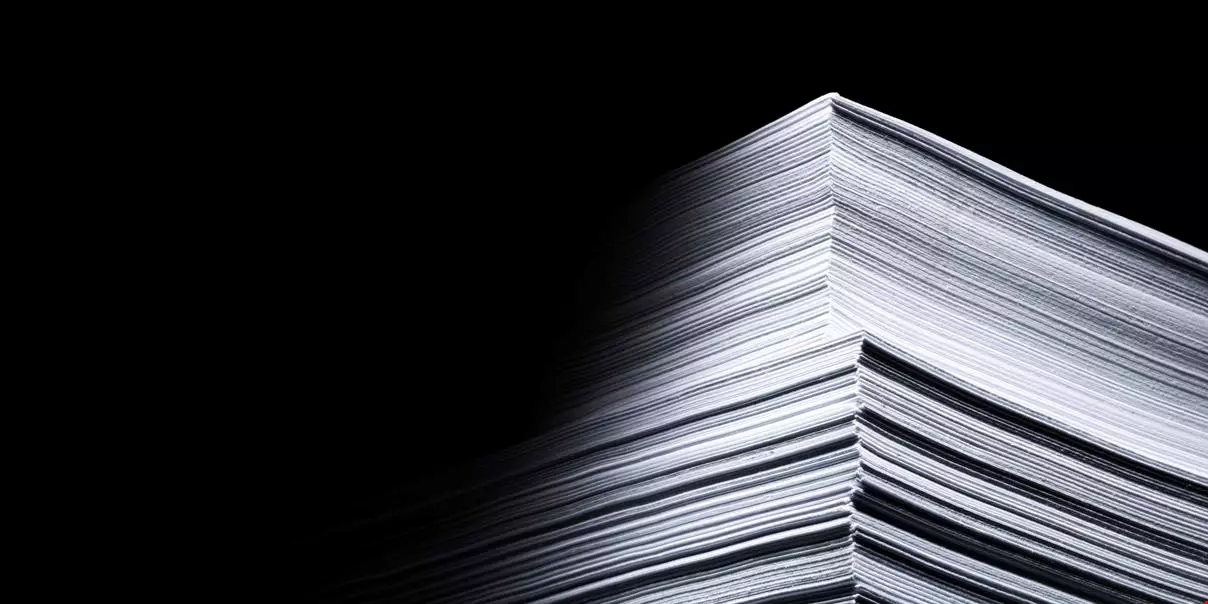 Stack of paper, dramatic, graphic, photographed in a dark invironment